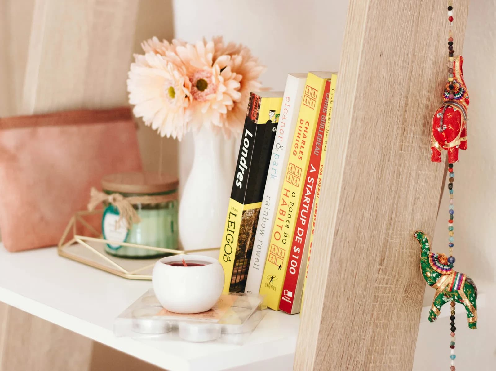A small shelf with a paw-print clay tile, a candle, and a framed photo.